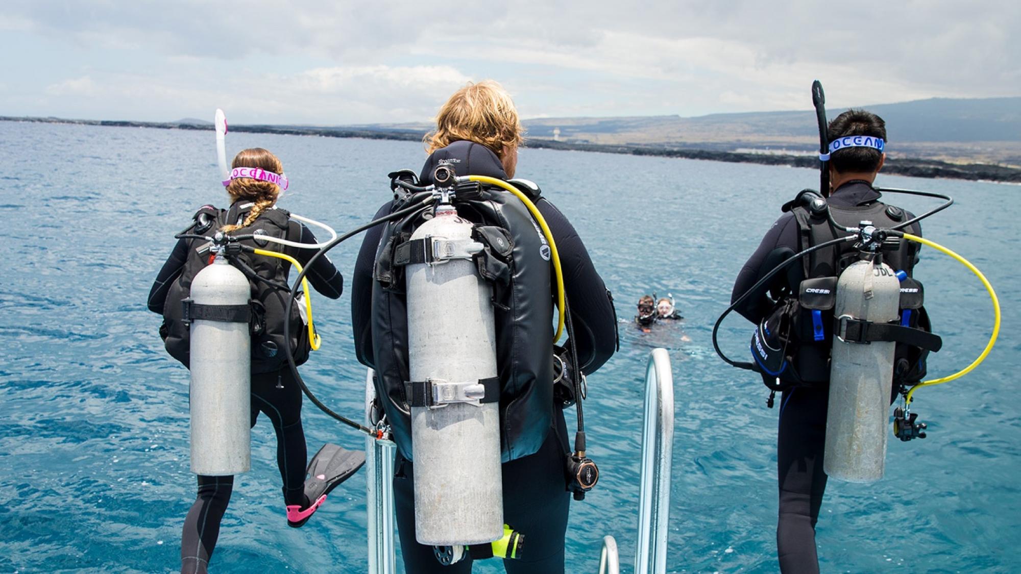 PADI Pro jumping into the ocean with a group to teach a Divemaster course